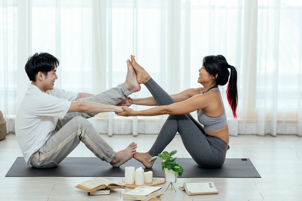 Asian couple doing Navasana posture