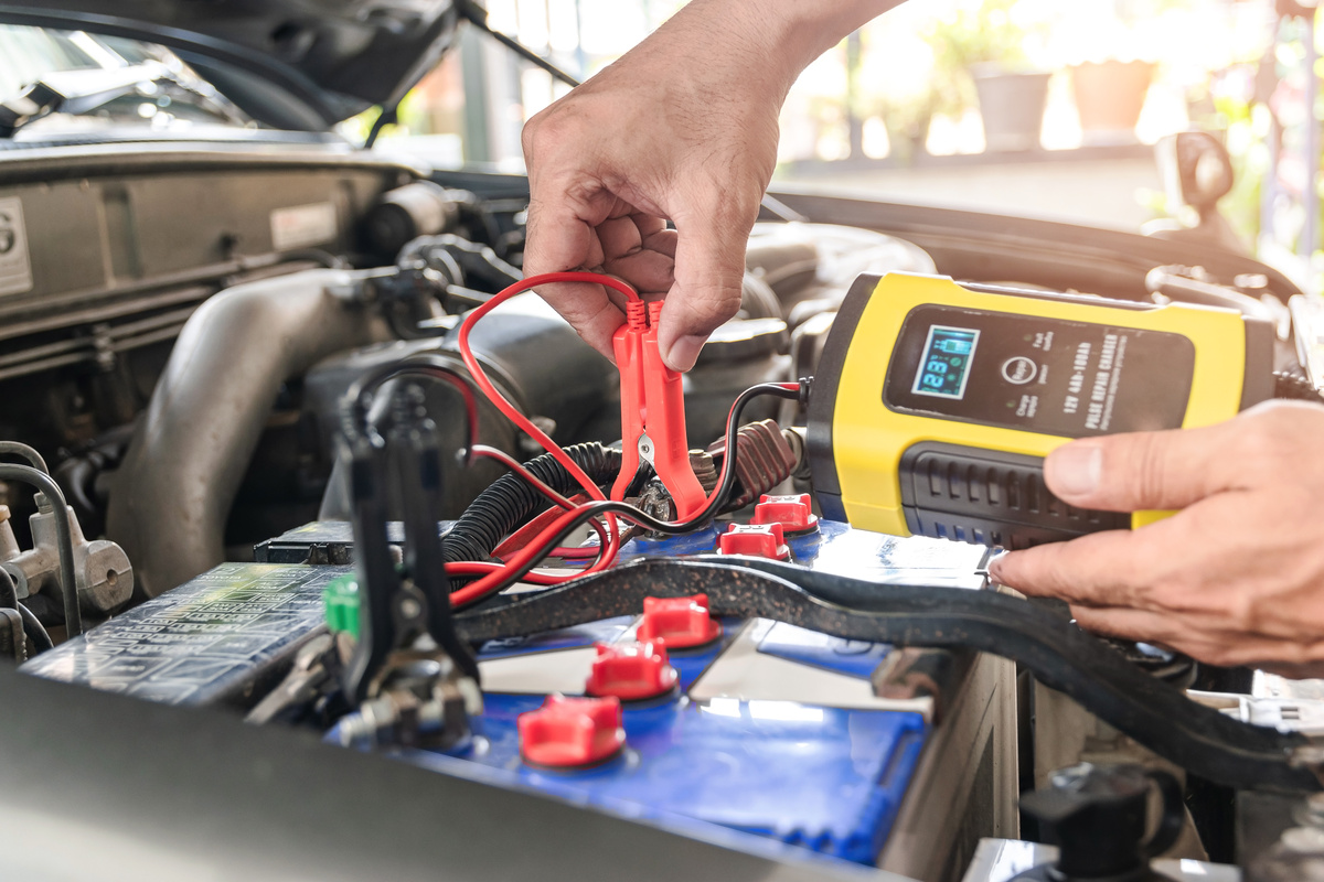 Person Checking on a Car Battery 